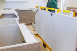 Workers lifting and installing maple granite counter in kitchen